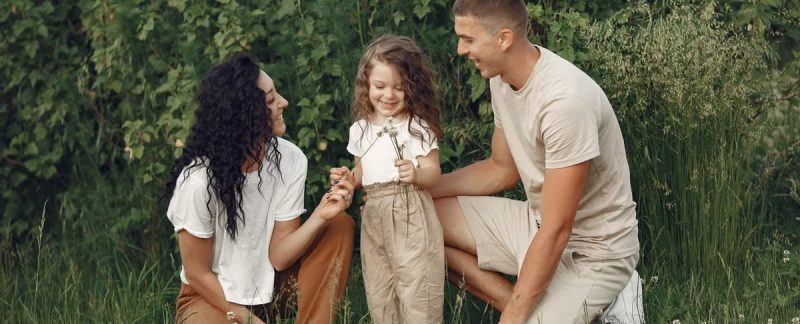 A joyful family enjoying time together in a lush green field.